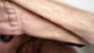 Couple on a made bed in an explicit scene