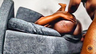 Amateur couple on a living room sofa in explicit scene