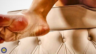 Amateur couple on a living room sofa in explicit scene