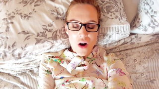Solo performer with a toy on rumpled bedsheets