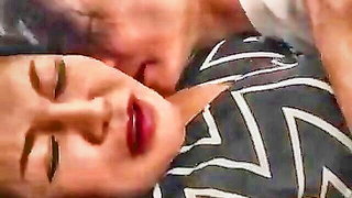 Couple mid-scene in a dim bedroom