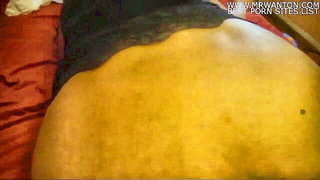 Couple on a made bed in an explicit scene