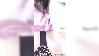 Solo performer with a toy on rumpled bedsheets