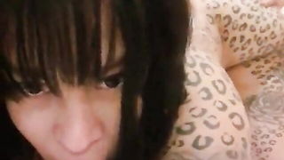 Solo performer with a toy on rumpled bedsheets