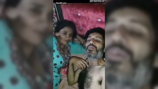 Couple on a patterned bedspread in an explicit scene