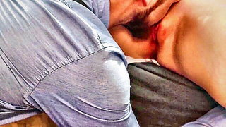 Couple on a made bed in an explicit scene