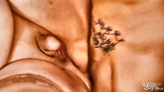 Couple on a made bed in an explicit scene