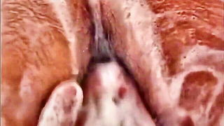 Couple on a made bed in an explicit scene