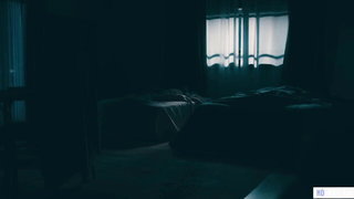 Couple mid-scene in a dim bedroom