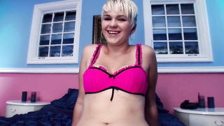 Solo performer with a toy on rumpled bedsheets