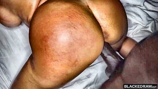 Couple on a made bed in an explicit scene