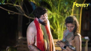 Couple on a patterned bedspread in an explicit scene
