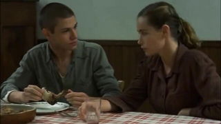 Couple on a made bed in an explicit scene
