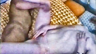 Couple on a patterned bedspread in an explicit scene