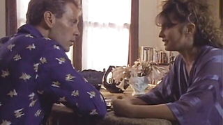 Couple on a patterned bedspread in an explicit scene