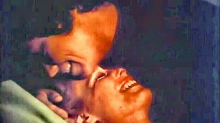 Couple mid-scene in a dim bedroom