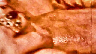 Couple on a made bed in an explicit scene