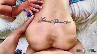Couple on a made bed in an explicit scene