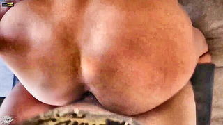 Amateur couple on a living room sofa in explicit scene