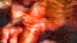 Couple mid-scene in a dim bedroom