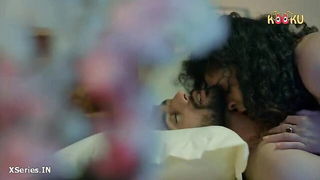 Couple on a patterned bedspread in an explicit scene