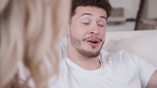 Amateur couple on a living room sofa in explicit scene