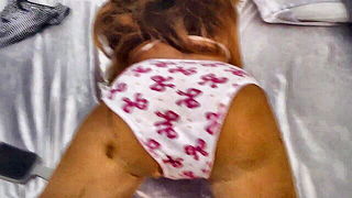 Solo performer with a toy on rumpled bedsheets