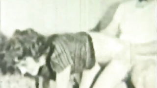 Couple on a patterned bedspread in an explicit scene