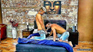 Couple on a patterned bedspread in an explicit scene