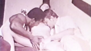 Couple on a made bed in an explicit scene