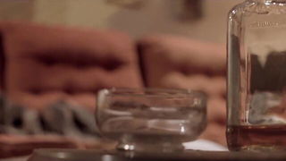 Couple on a made bed in an explicit scene
