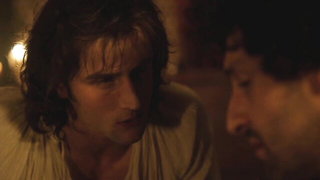 Couple mid-scene in a dim bedroom