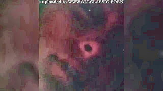 Solo performer with a toy on rumpled bedsheets