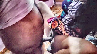 Couple on a patterned bedspread in an explicit scene