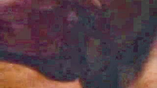 Couple on a made bed in an explicit scene