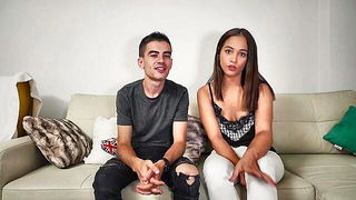 Amateur couple on a living room sofa in explicit scene