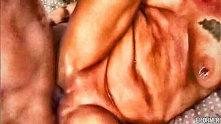 Solo performer with a toy on rumpled bedsheets