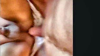 Couple on a made bed in an explicit scene
