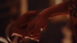 Couple on a made bed in an explicit scene