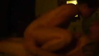Couple mid-scene in a dim bedroom