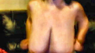 Amateur couple on a living room sofa in explicit scene