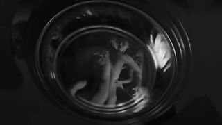 Couple on a made bed in an explicit scene