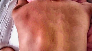 Explicit massage scene in a softly lit room
