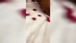 Couple on a patterned bedspread in an explicit scene