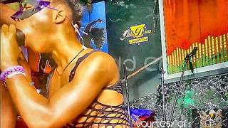Studio set with performers in an explicit scene under bright lights