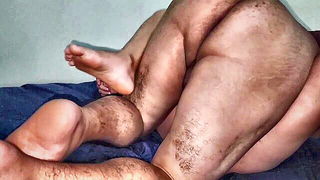 Couple on a made bed in an explicit scene
