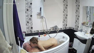 Couple on a patterned bedspread in an explicit scene
