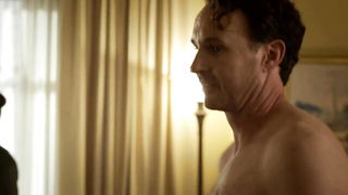 Couple on a made bed in an explicit scene