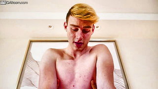 Solo performer with a toy on rumpled bedsheets