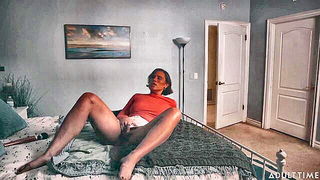 Solo performer with a toy on rumpled bedsheets